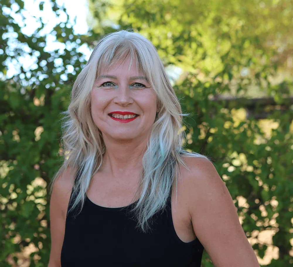 Portrait of Janine Strumpher, Fundraiser, photographed among the trees at Camphill Village.