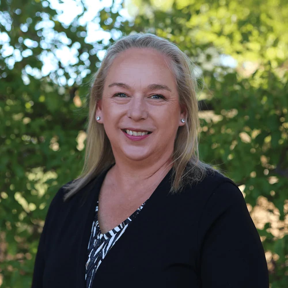 Portrait of Elma Anderson, Human Resources, photographed among the trees at Camphill Village.