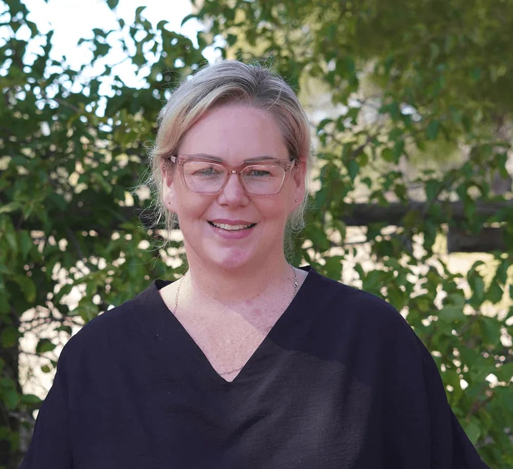 Portrait of Carine Human, Social Worker & Admissions, photographed among the trees at Camphill Village.